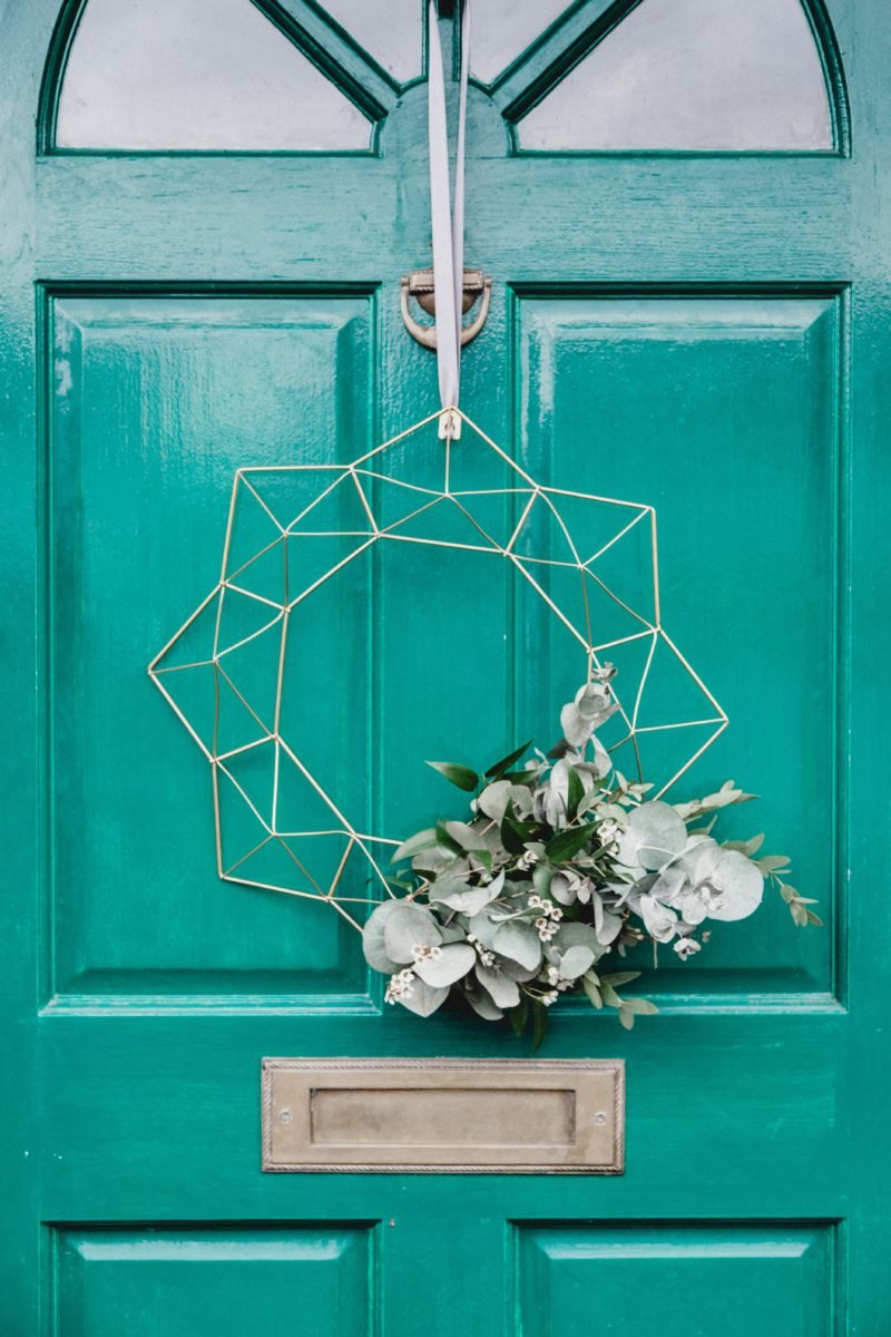 Green front door with wreath