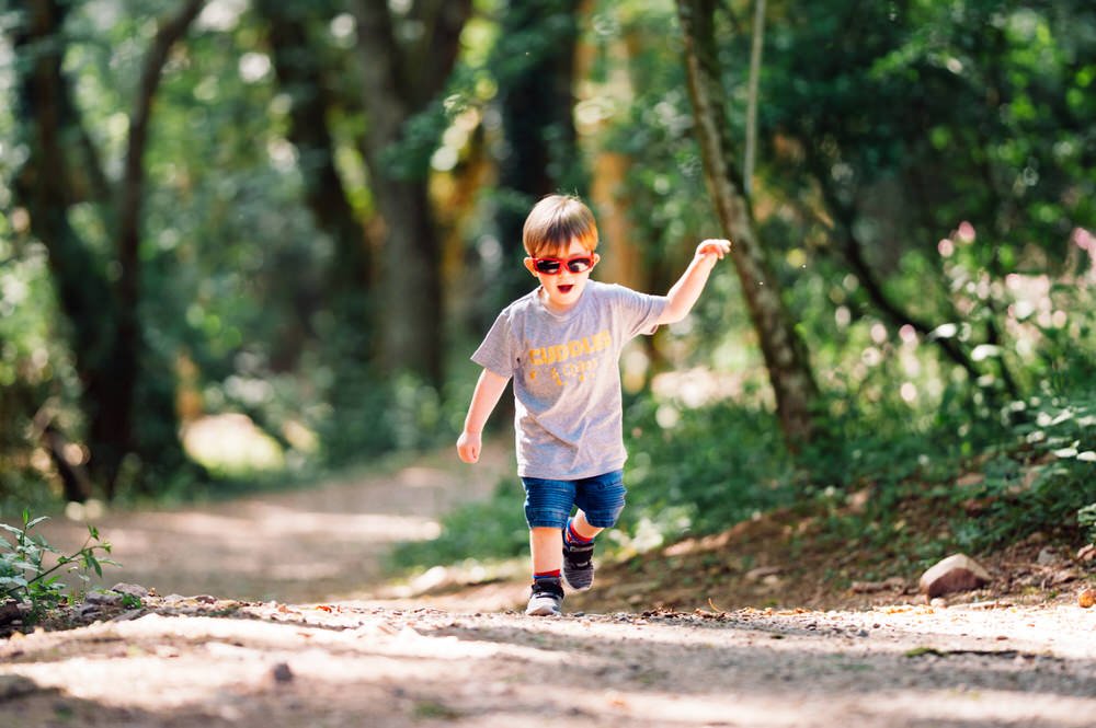 Toddler running in the woods in Bluestone 