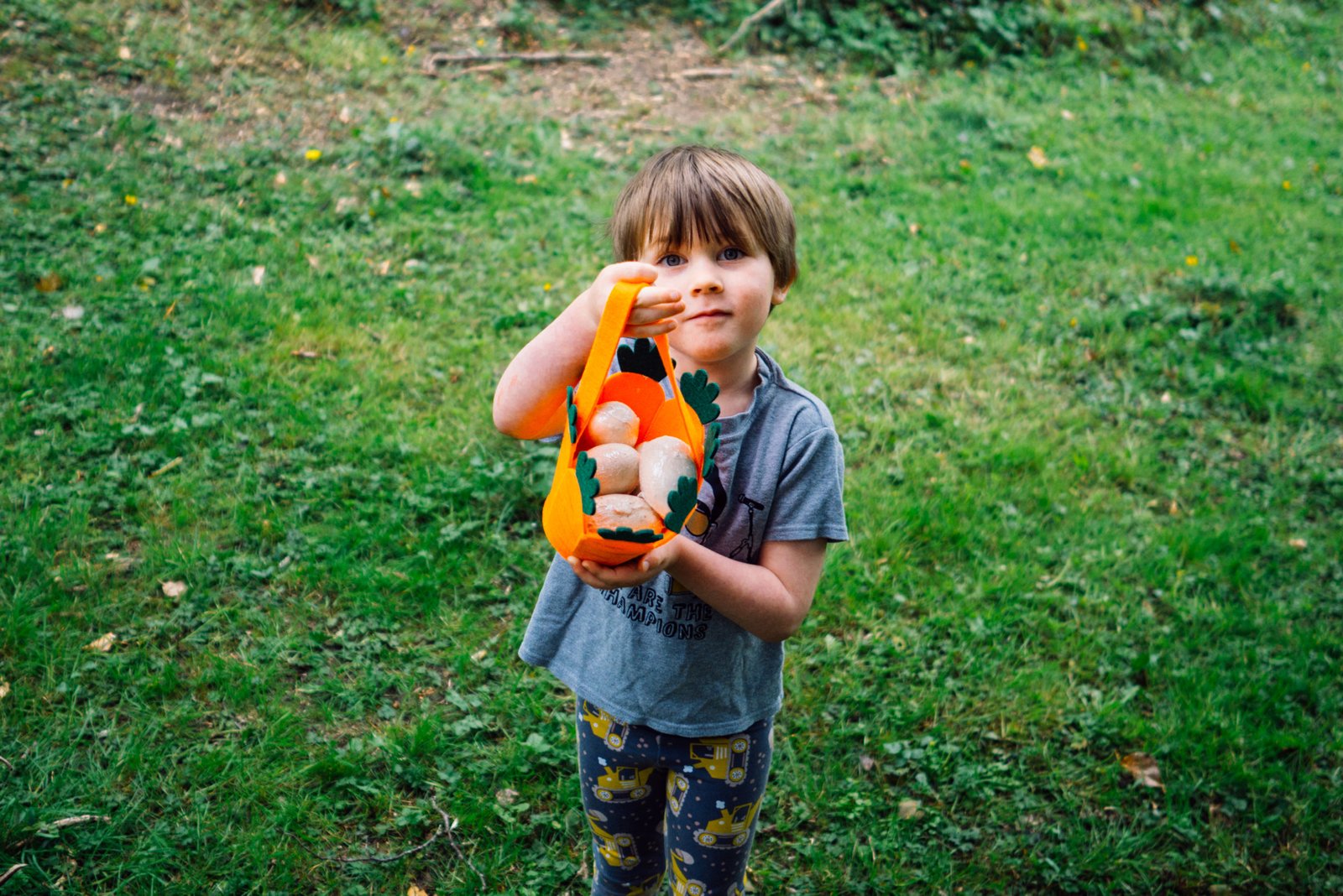 child with easter basket full of eggs 