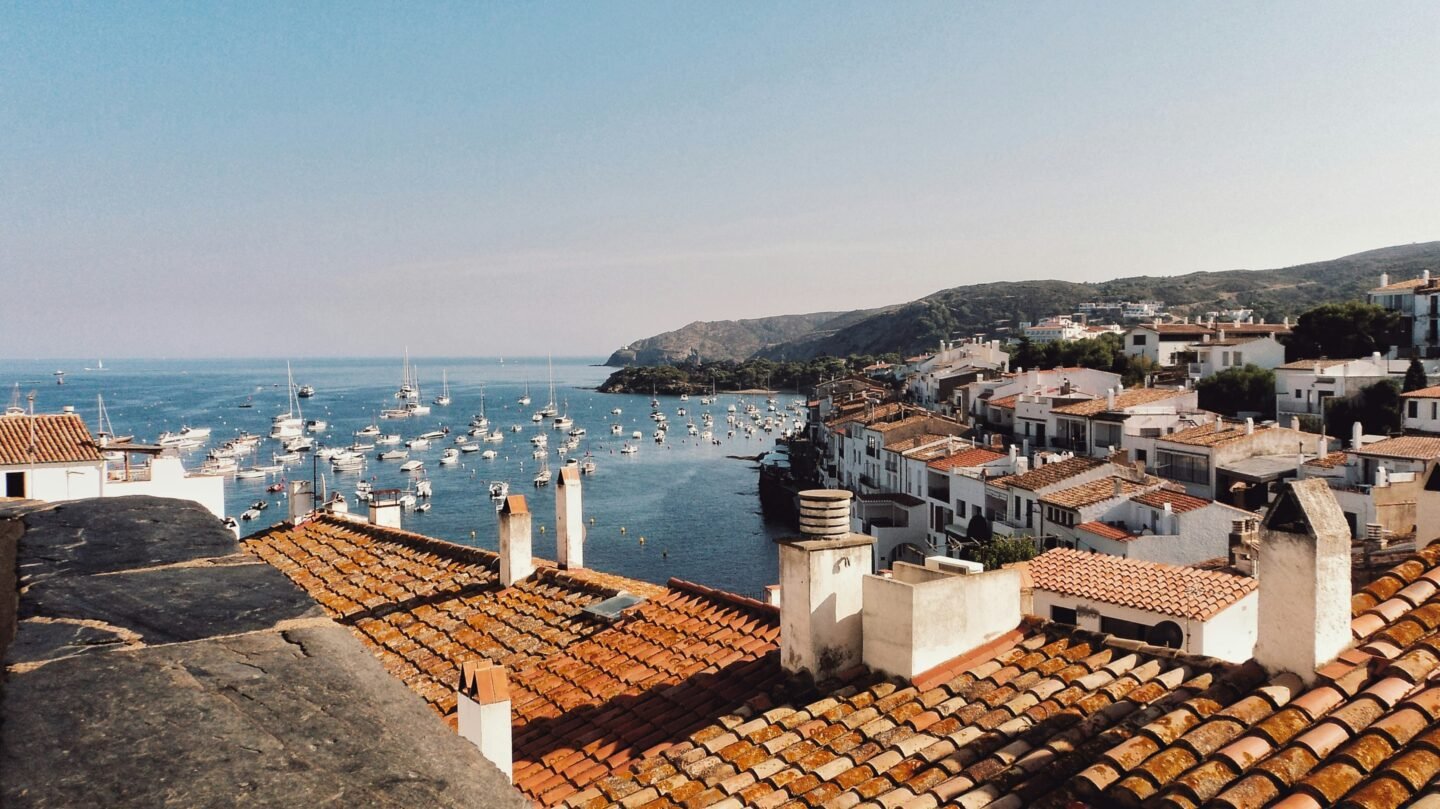 Boats moored on calm water beside a mountain on the Spanish coast